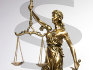 Figur der Justizia mit einem Paragraphen als Wasserzeichen im Hintergrund