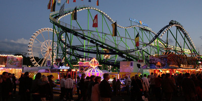 Eine nächtliche Szene des Schützenfestes mit Achterbahn.