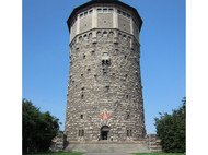 Aussenfassade eines historischen Wasserturms mit blauen Himmel 
