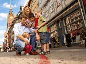 Eine Familie schaut in den roten Faden.
