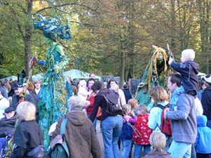 Verkleidete Schauspieler auf Stelzen bewegen sich durch Menschenmenge auf dem Tiergartenfest