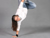 Eine junge Frau macht einen Handstand vor einem grauen Hintergrund