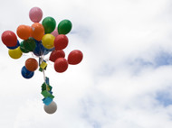 Ein Bund bunter Luftballons steigt in die Luft