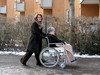 Frau schiebt eine andere Frau im Rollstuhl. 