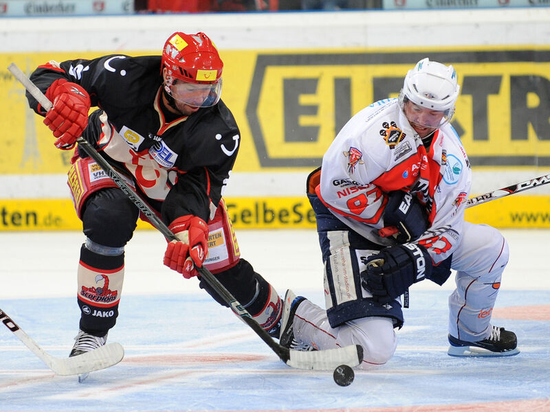 Zwei Eishockeyspieler kämpfen um den Bully.