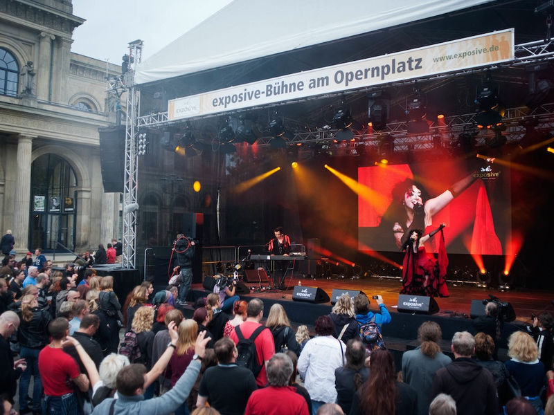 Musiker auf überdachter Bühne mit Publikum