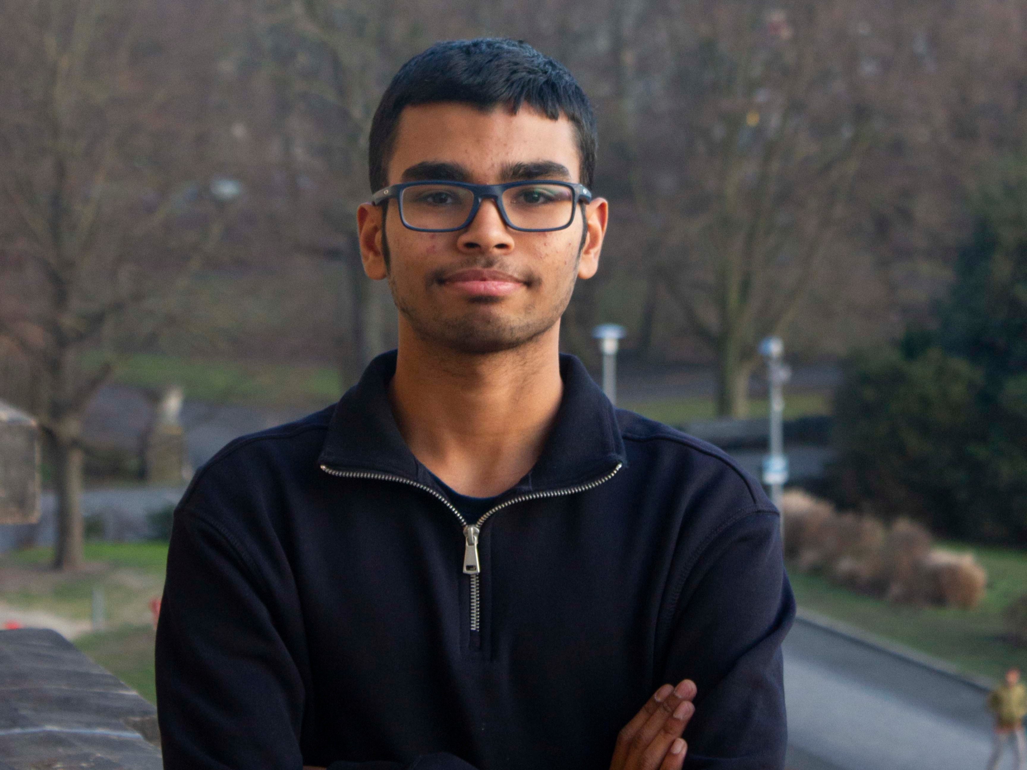 Ein junger Mann mit Brille schaut in die Kamera.