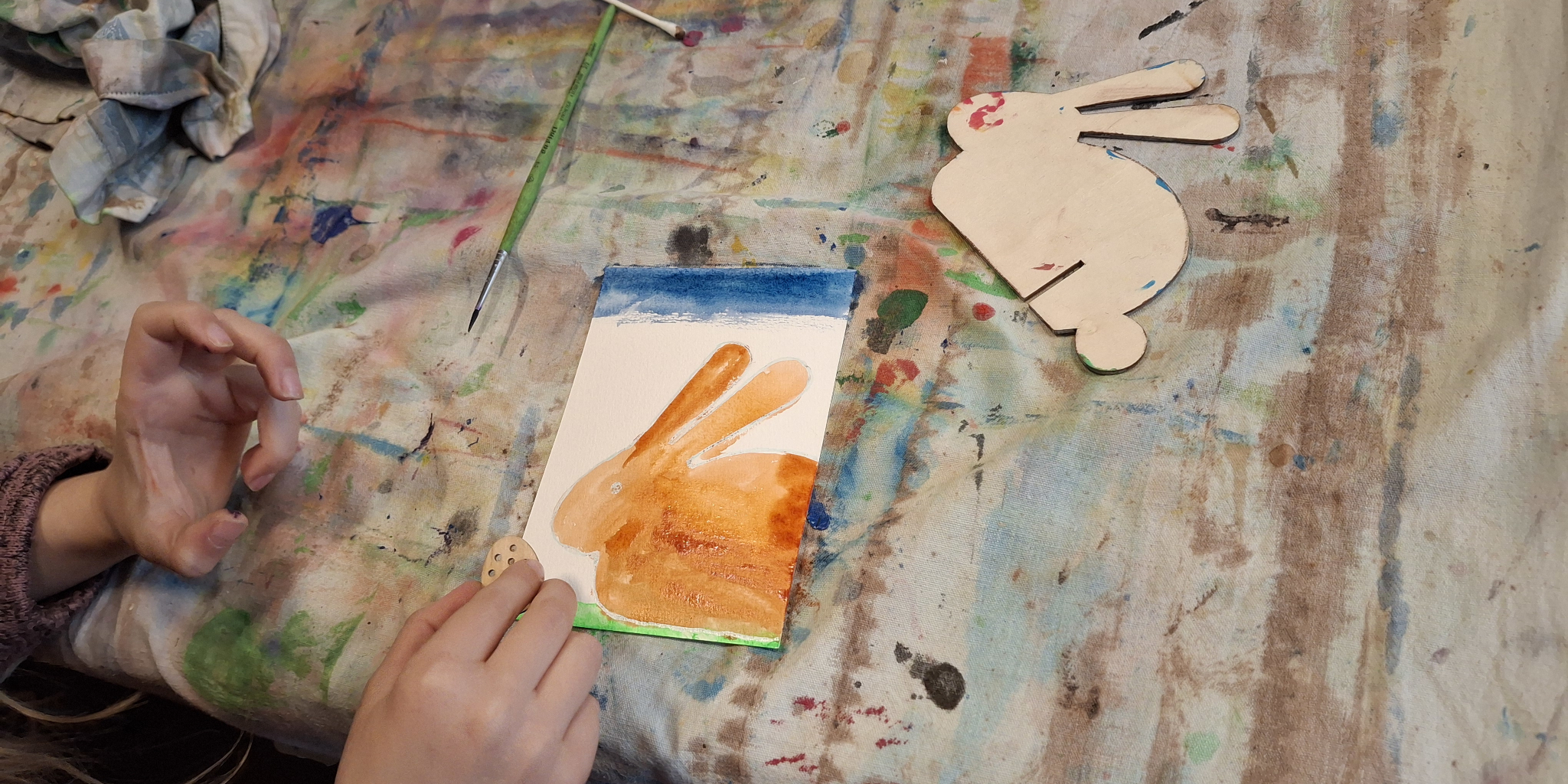 Ein Kind malt eine Osterkarte