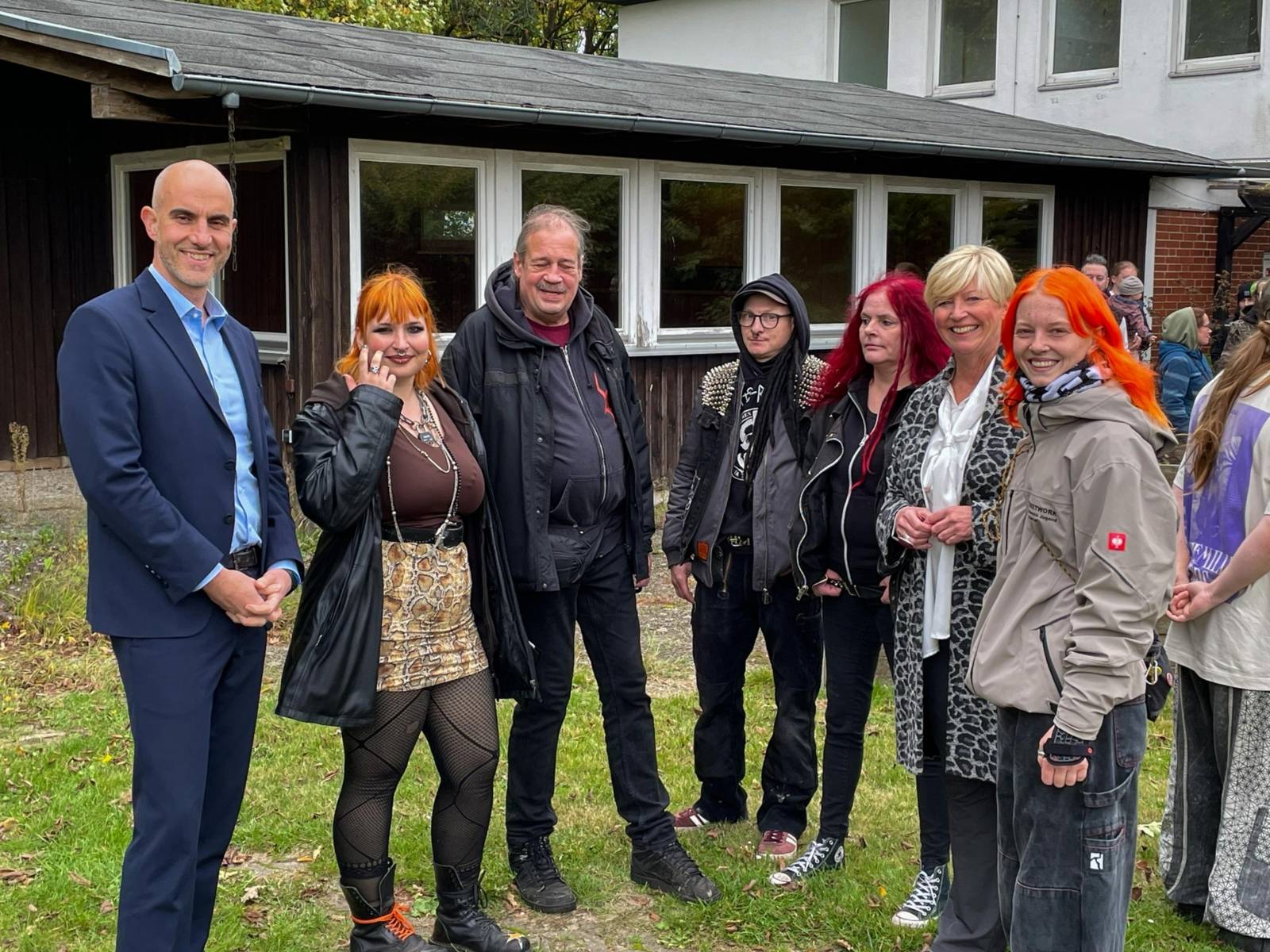 Mehrere Personen auf einem Grundstück im Grünen.