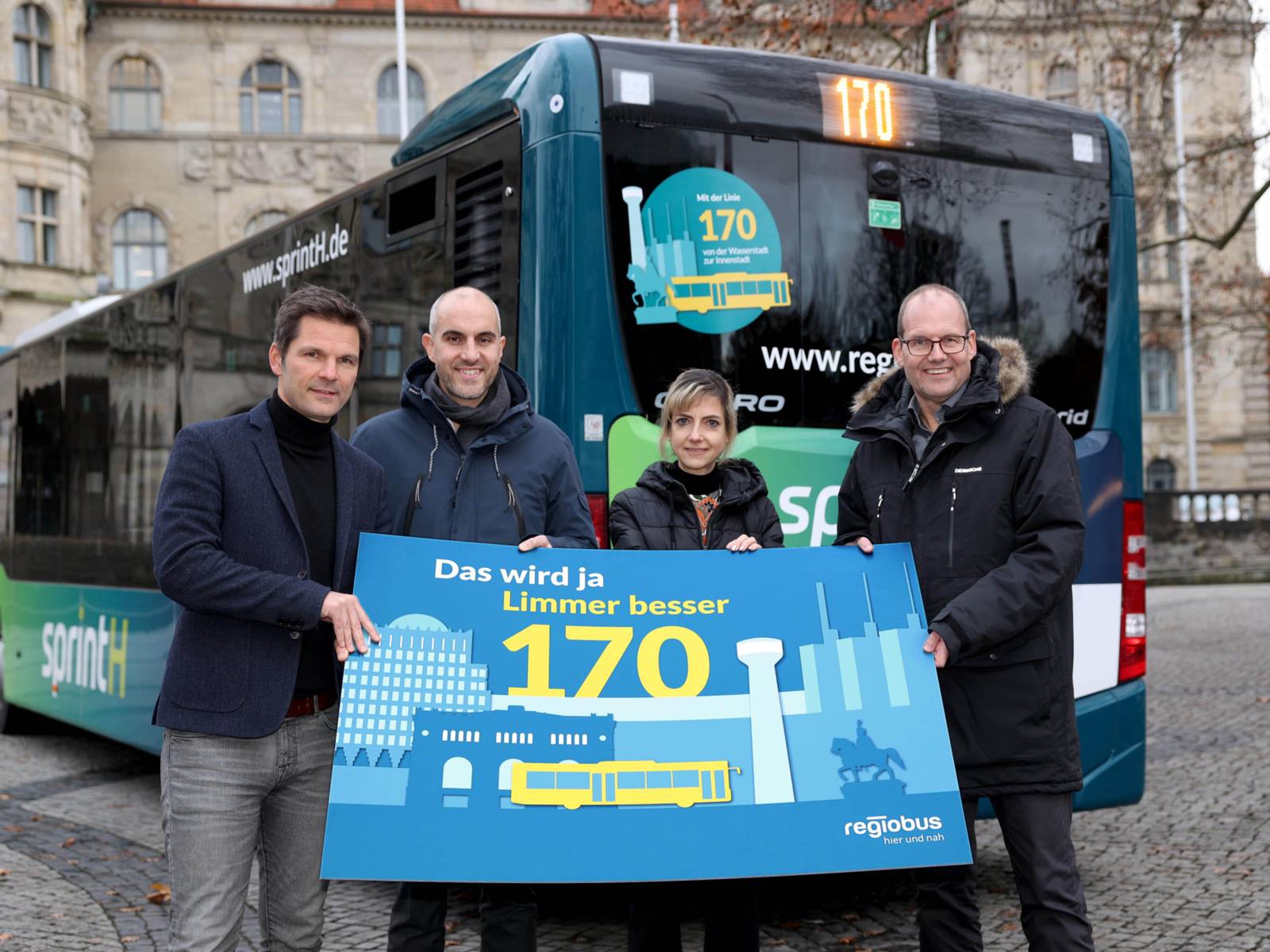 Vier Menschen halten ein Plakat hoch, auf dem die neue Regiobus Linie 170 beworben wird