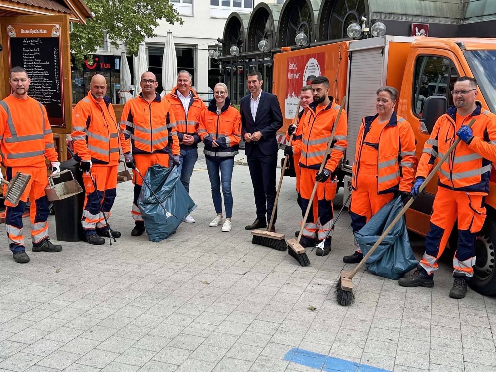 Eine Gruppe von Mitarbeitern der Stadtreinigung steht zusammen mit Axel von der Ohe, Robert Krause und Julia Fürst.