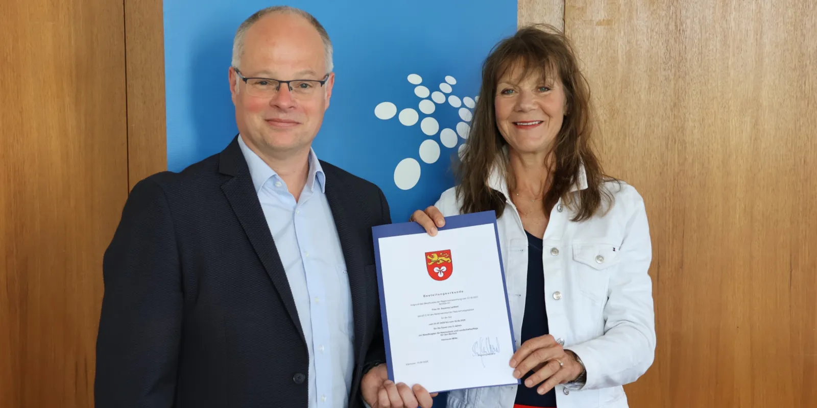 Ein Mann und eine Frau halten eine Urkunde