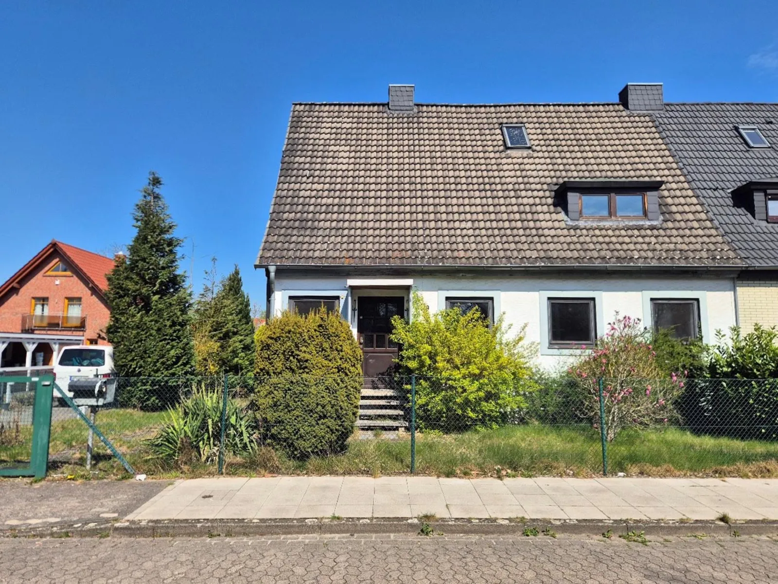 Ein bebautes Grundstück von der Straße aus betrachtet.