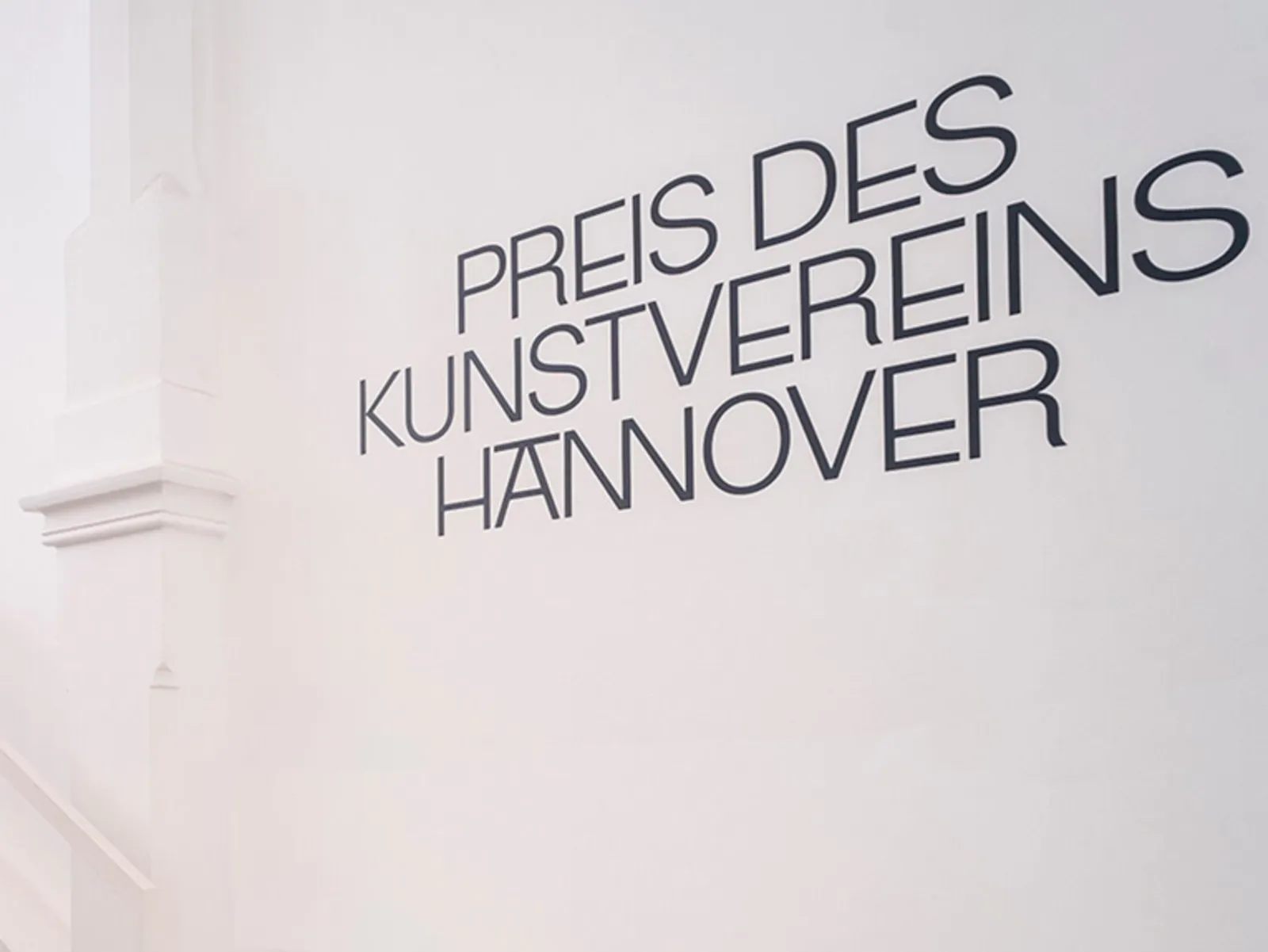 Das Foto zeigt eine weiße Wand in den Räumlichkeiten des Kunstvereins Hannover, auf der der Schriftzug „Preis des Kunstvereins Hannover“ steht.