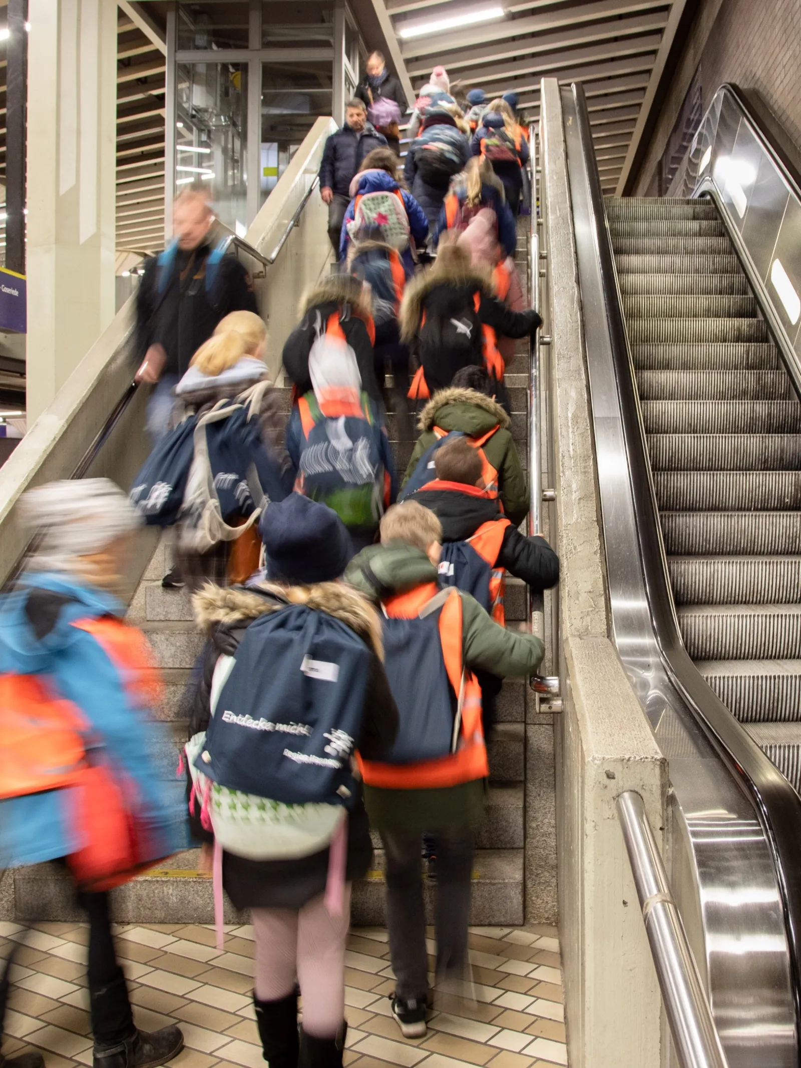 Kinder nehmen die Rolltreppe in einer Stadtbahnstation.