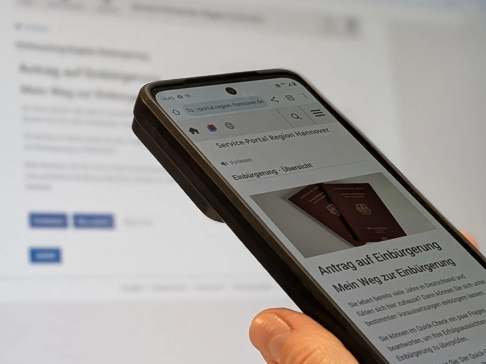 Ein Smartphone mit einer Anwendung vor einem Bildschirm