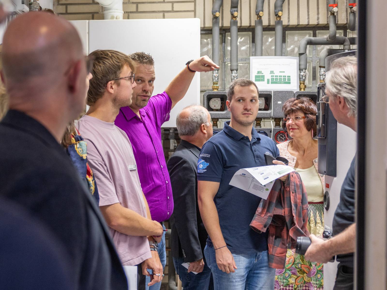 Gruppe von Personen in einem Heizungsraum