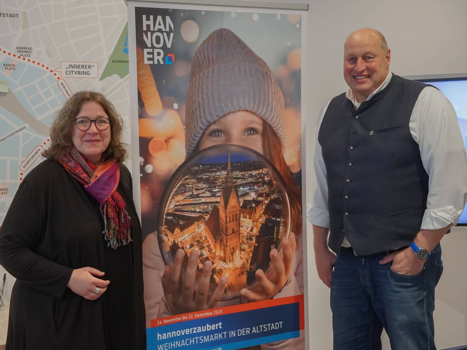 Zwei Personen neben einem Aufsteller.