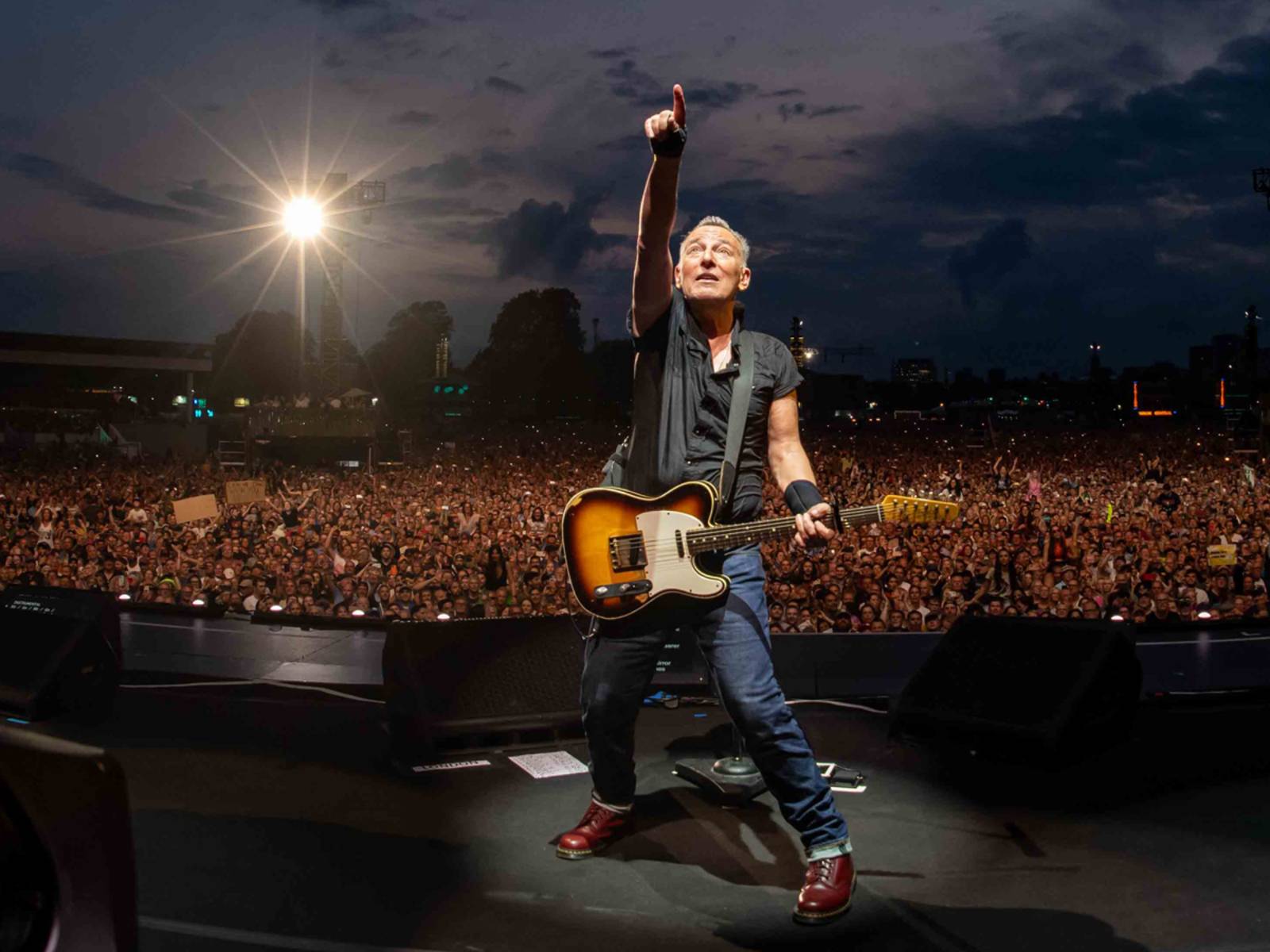 Bruce Springsteen auf einer Bühne vor einer Menschenmasse.
