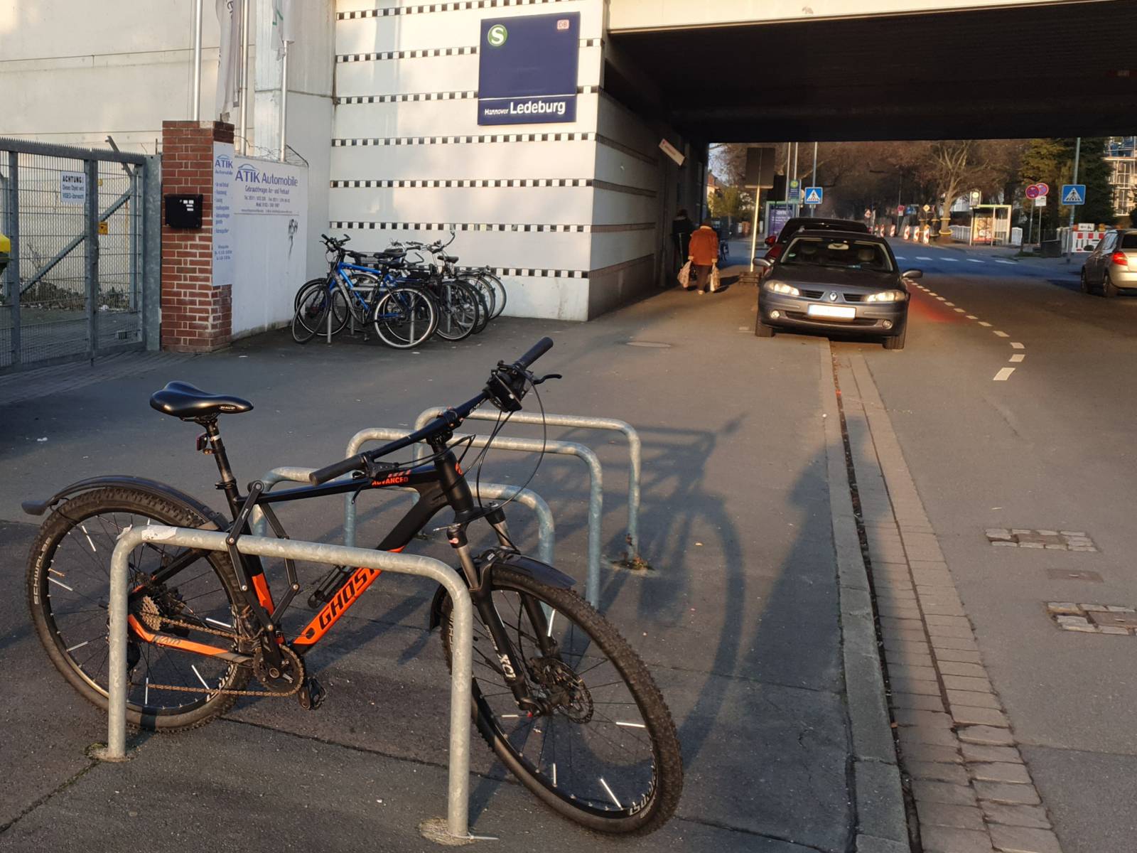 Ein Fu&szlig;weg, rechts eine Stra&szlig;e mit einer Unterf&uuml;hrung. Auf dem Fu&szlig;weg befinden sich vorne vier Fahrradb&uuml;gel, ein Rad ist angeschlossen, hinten links stehen weitere R&auml;der an Fahrradb&uuml;geln v&uuml;r einer Wand, an der ein blaues Schild h&auml;ngt, auf dem Ledeburg zu lesen ist.