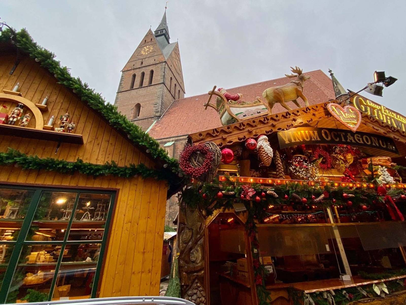 Zwei weihnachtlich dekorierte Holzbuden. Im Hintergrund der Turm der Marktkirche Hannover.
