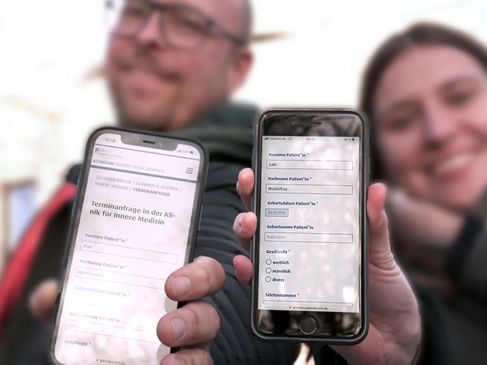 Eine Frau und ein Mann halten Smartphones in die Kamera.