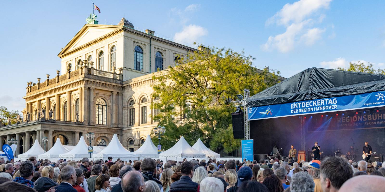 Ein Platz mit vielen Menschen, die Oper Hannover und eine B&uuml;hne mit einer Band.