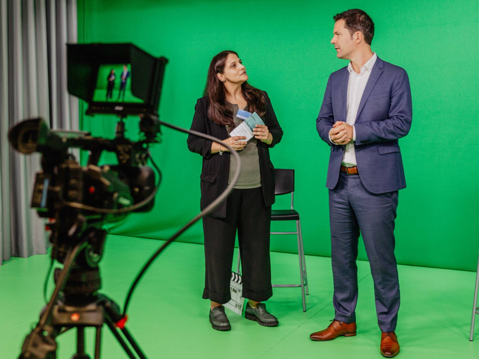 Zwei Personen vor einem "Green Screen".