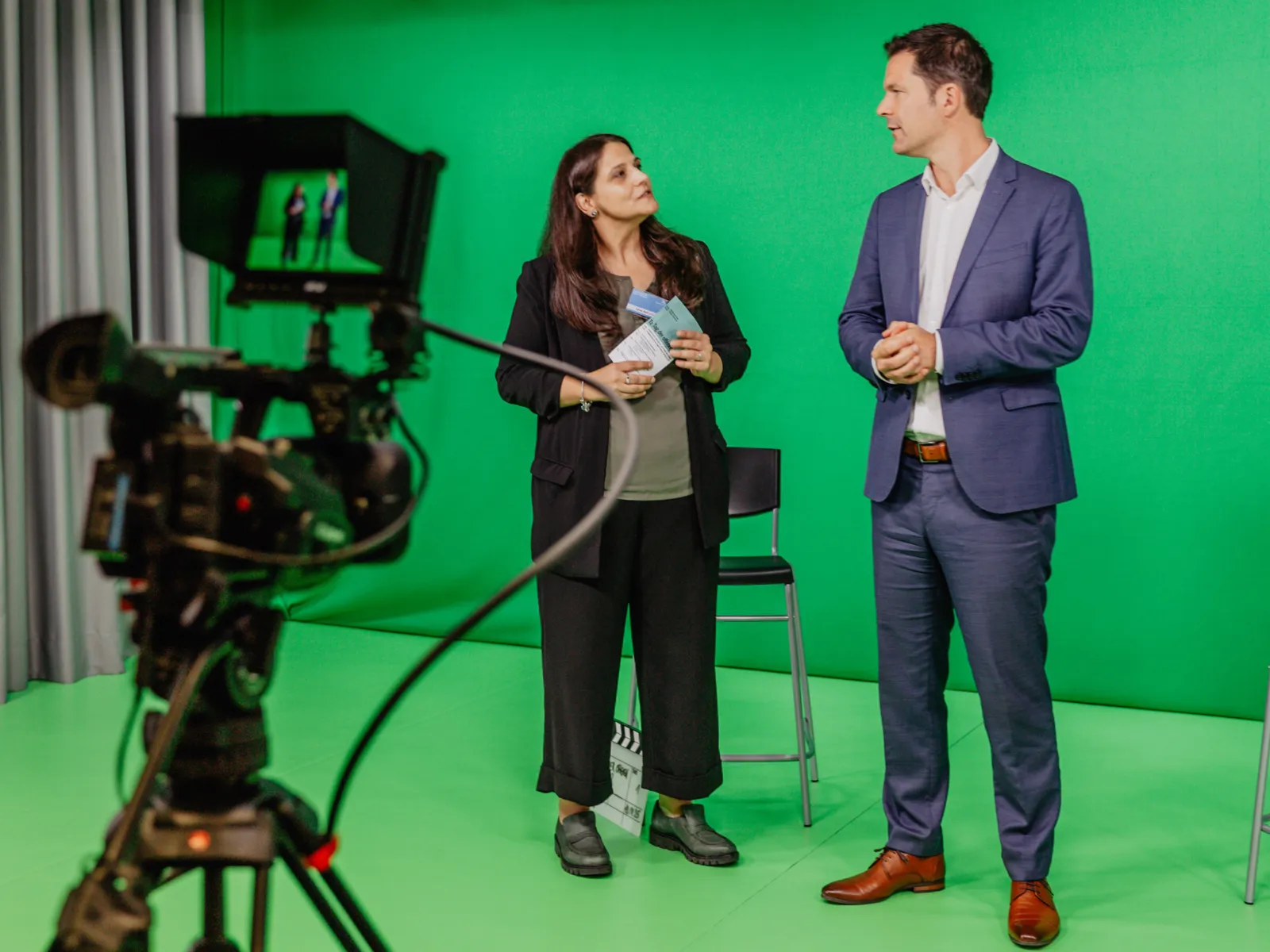 Zwei Personen vor einem "Green Screen".