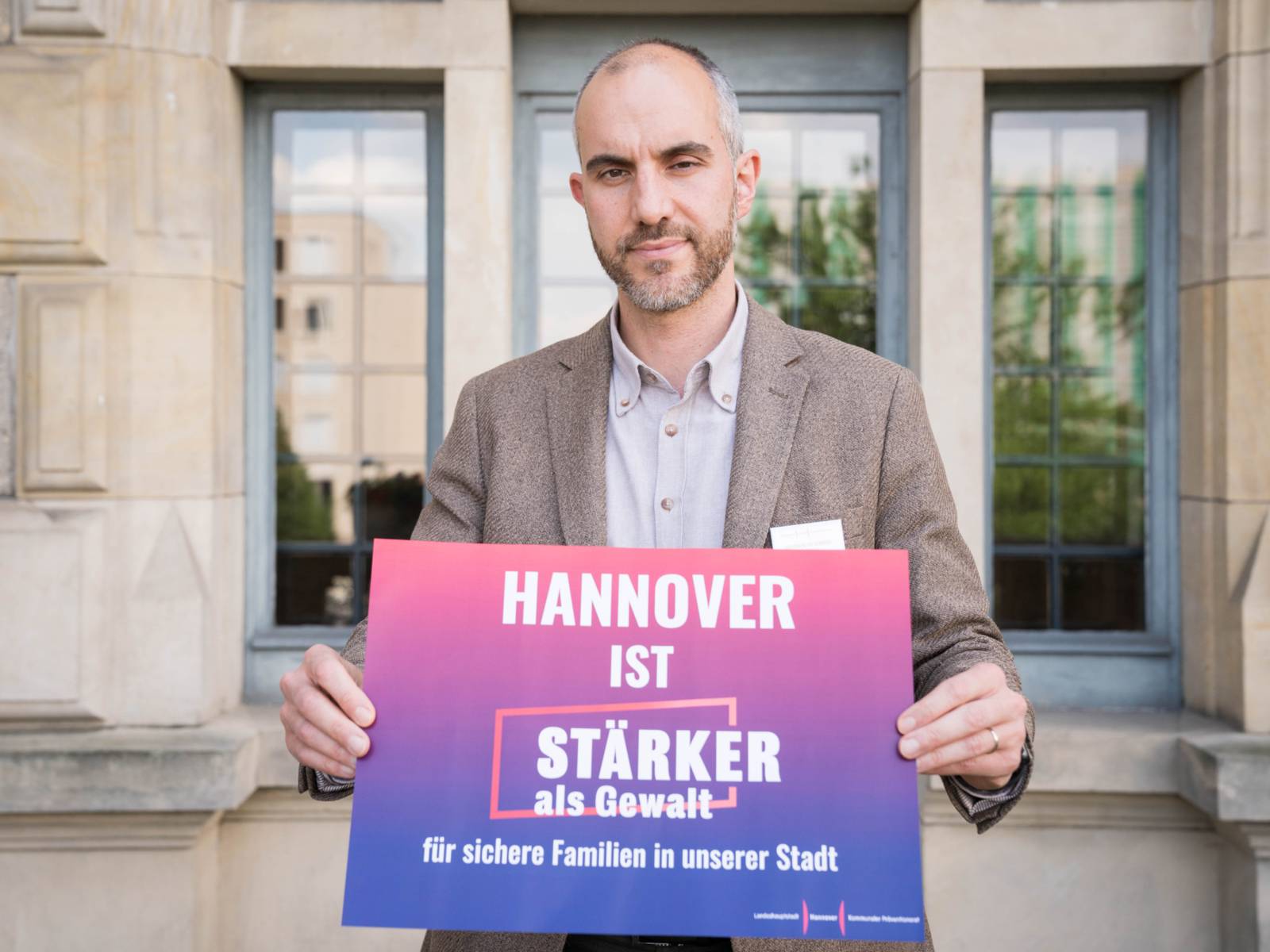 Oberbürgermeister Belit Onay mit einem Schild "Hannover ist stärker als Gewalt"
