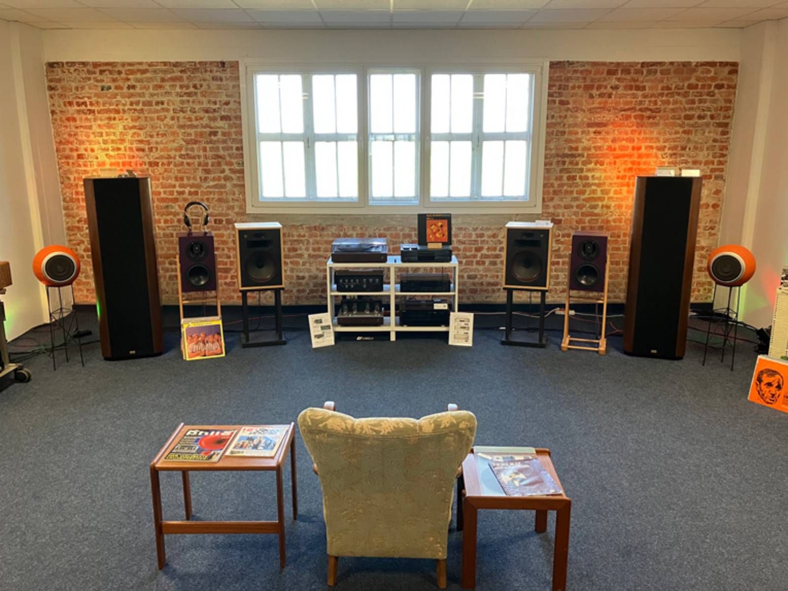 Ein Raum mit einem Sessel und vielen Lautsprechern