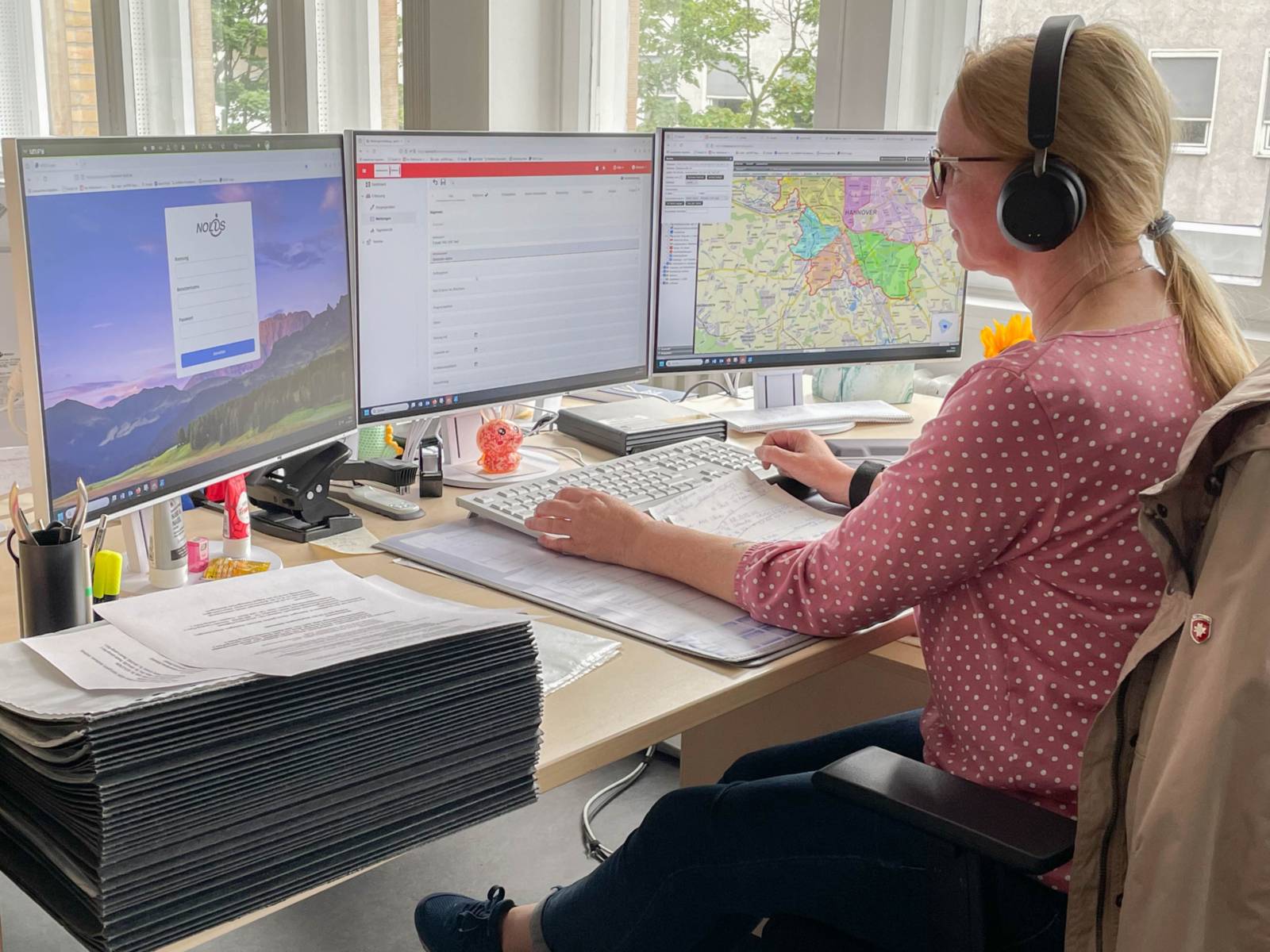 Eine Mitarbeiterin des Ordnungs- und Verkehrsaußendienstes sitzt an einem Schreibtisch mit drei Bildschirmen.