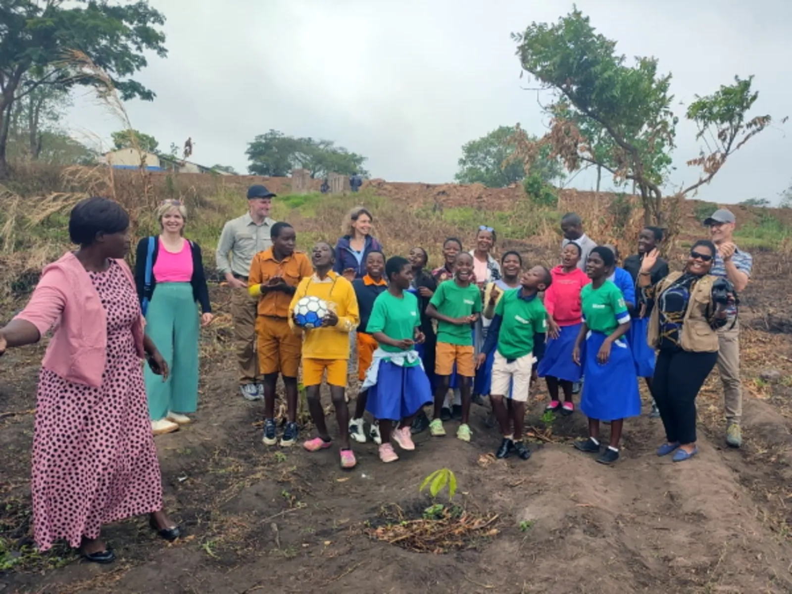 Das Projektteam, Schüler*innen und Lehrkräfte der Namiwawa Primary School mit einem Setzling.