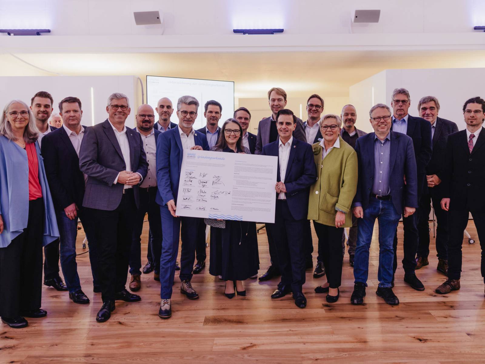 Menschen mit einem großen unterschriebenen Dokument.