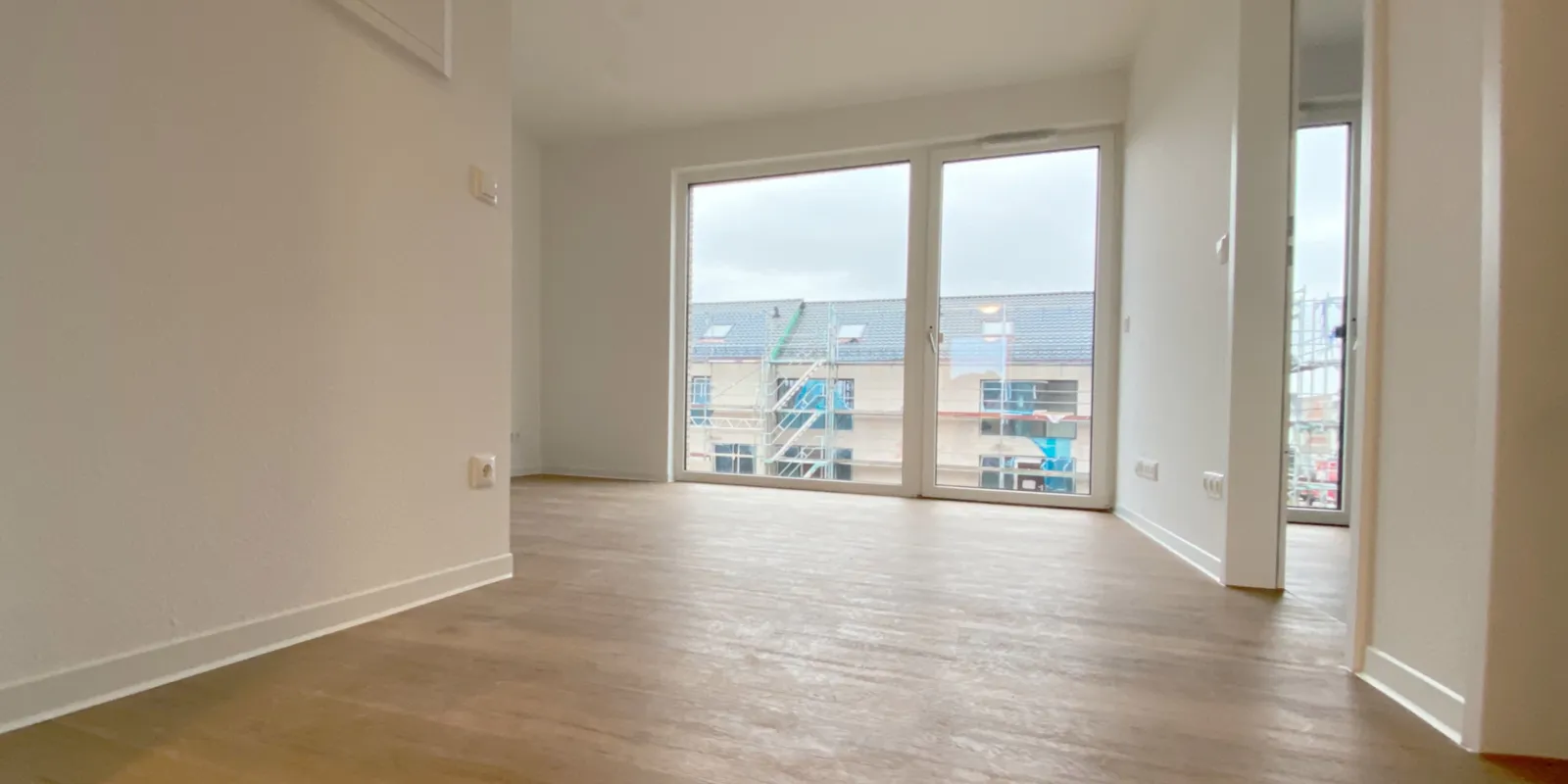 Blick in eine leer stehende, moderne Wohnung mit wei&szlig;en W&auml;nden.