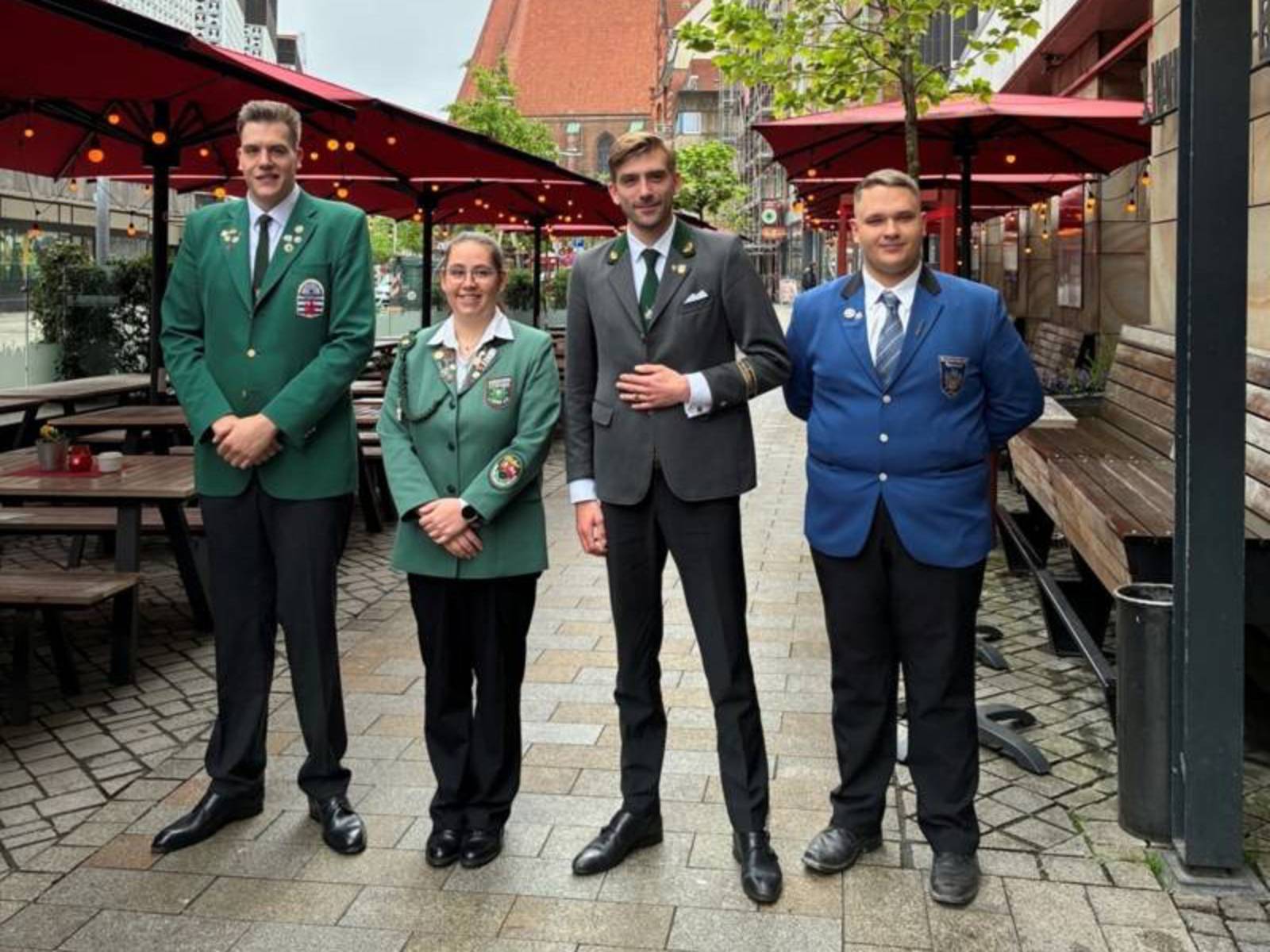 Vier Personen in Anzügen.