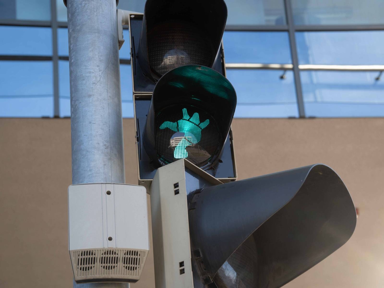 Nahaufnahme eines Ampelsignals für Fußgänger. Das grüne Licht hat die Form einer üppigen Frauenfigur nach dem Vorbild der Nanas von Hannover.