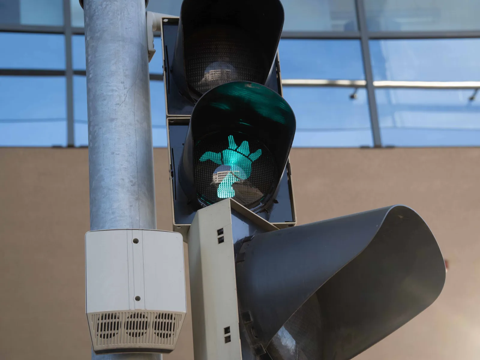 Nahaufnahme eines Ampelsignals für Fußgänger. Das grüne Licht hat die Form einer üppigen Frauenfigur nach dem Vorbild der Nanas von Hannover.