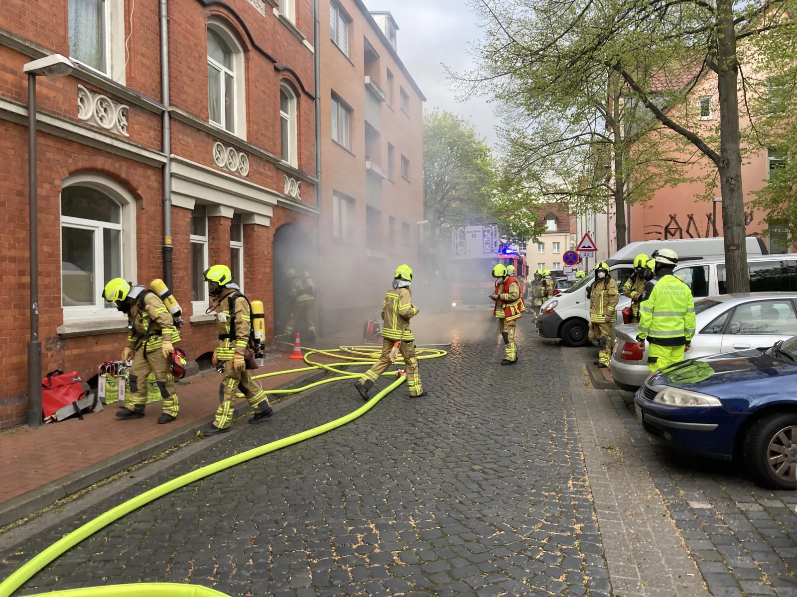 Brandrauch strömt aus einem Hauseingang.