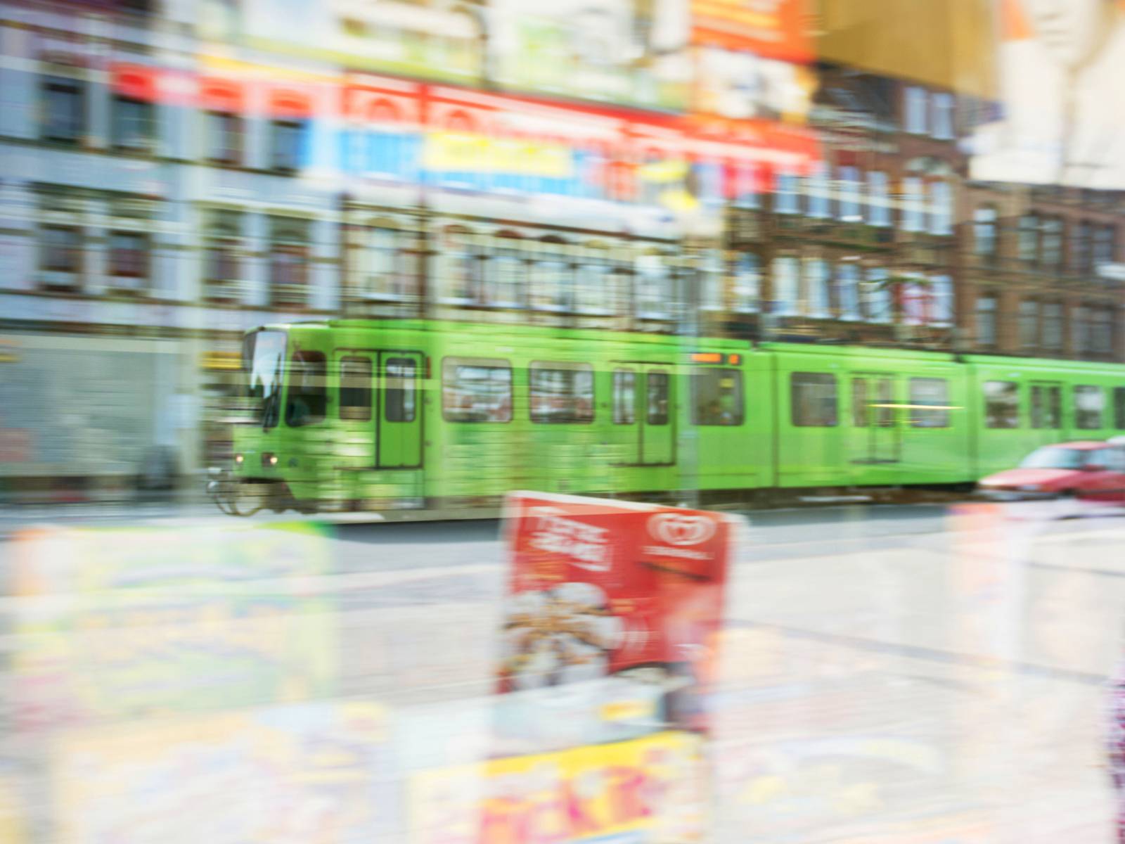 Stadtbahn gespiegelt im Schaufenster von einem Kiosk