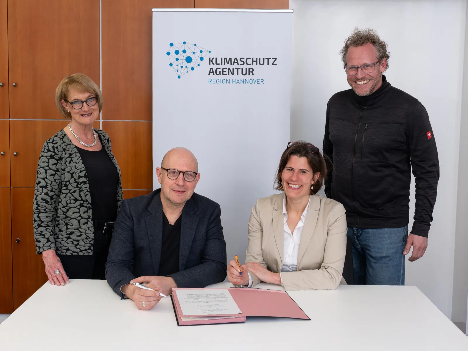 Vier Personen bei einer Vertragsunterzeichnung