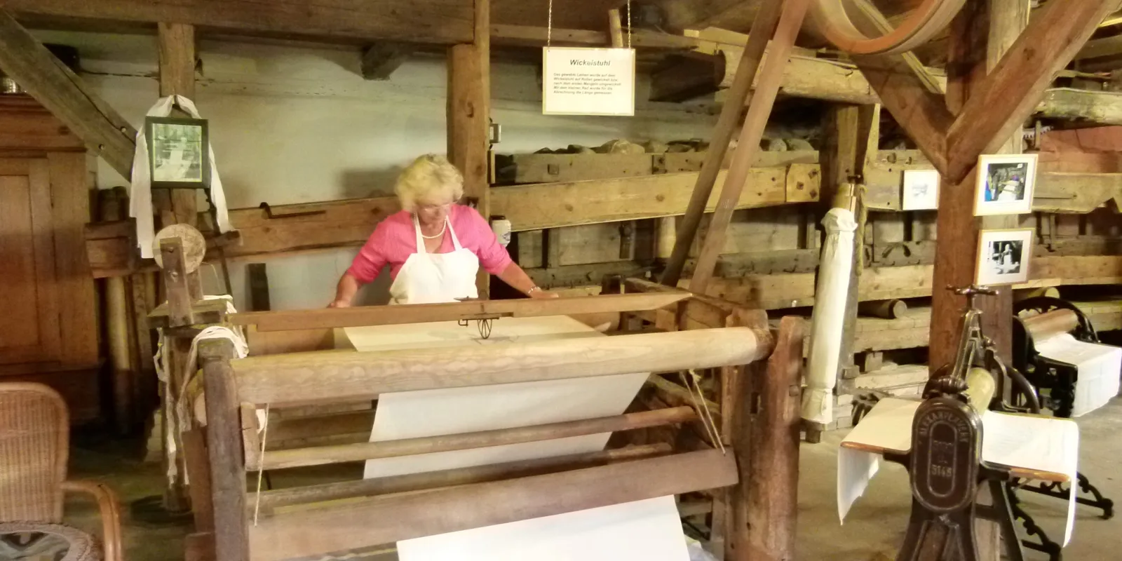 Eine Frau arbeitet an einer historischen Kastenmangel