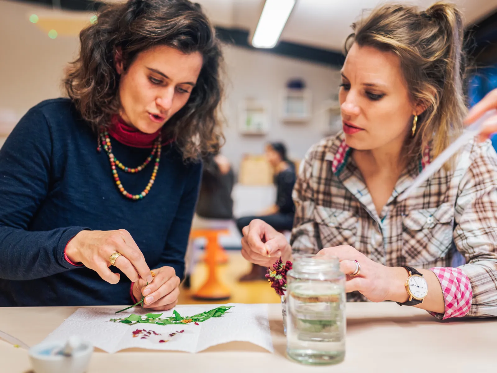 Zwei Frauen experimentieren mit Blüten.