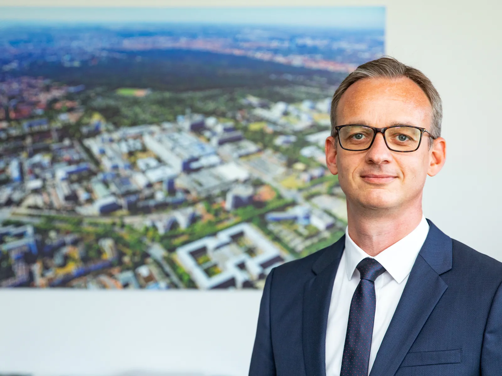 Sascha Zenker vor einem Großfoto der Medizinischen Hochschule Hannover