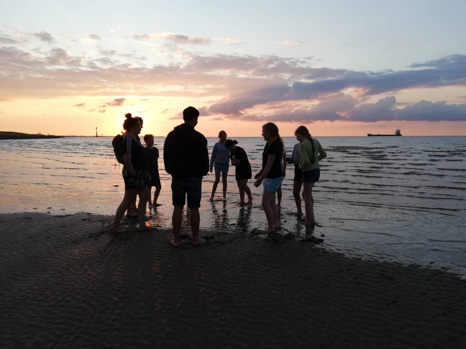 Jugendliche am Strand beim Sonnenuntergang