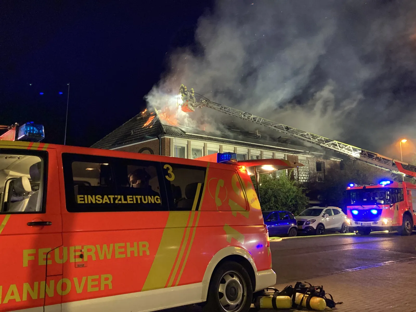 Rote Flammen schlagen aus einem Hausdach.
