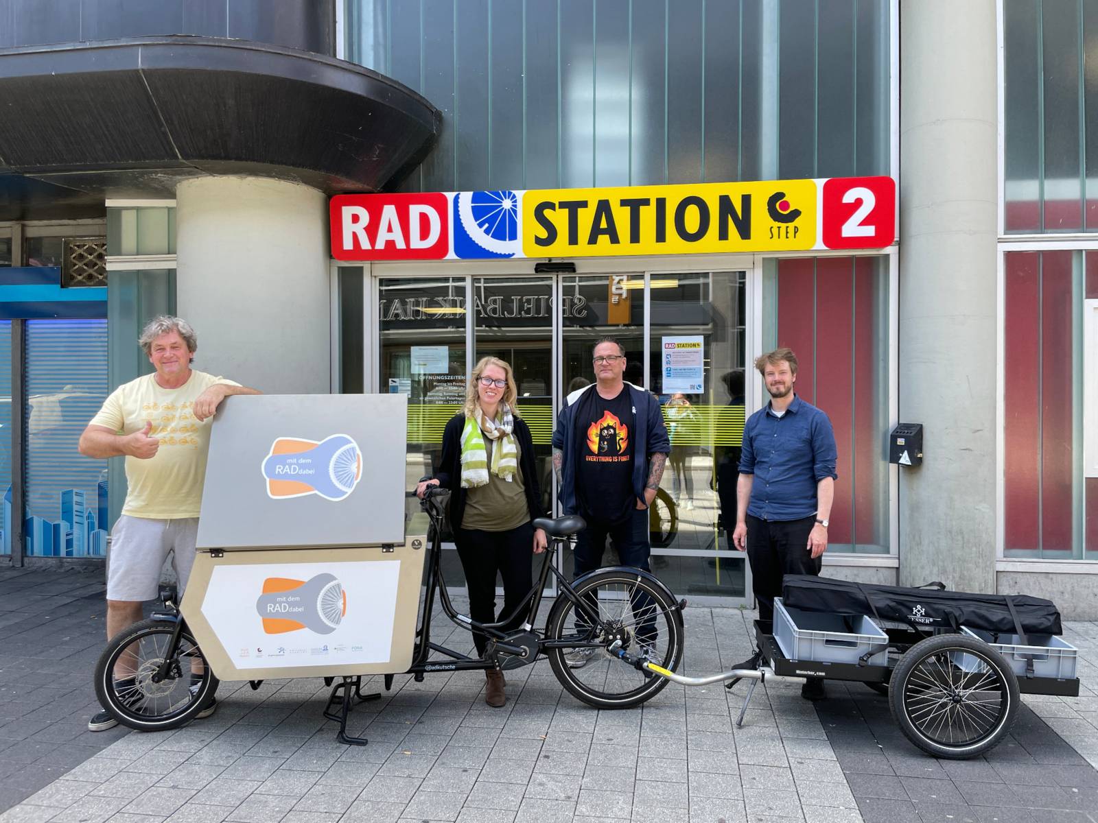 Vier Personen präsentieren eine mobile Fahrradwerkstatt, ein Lastenrad.