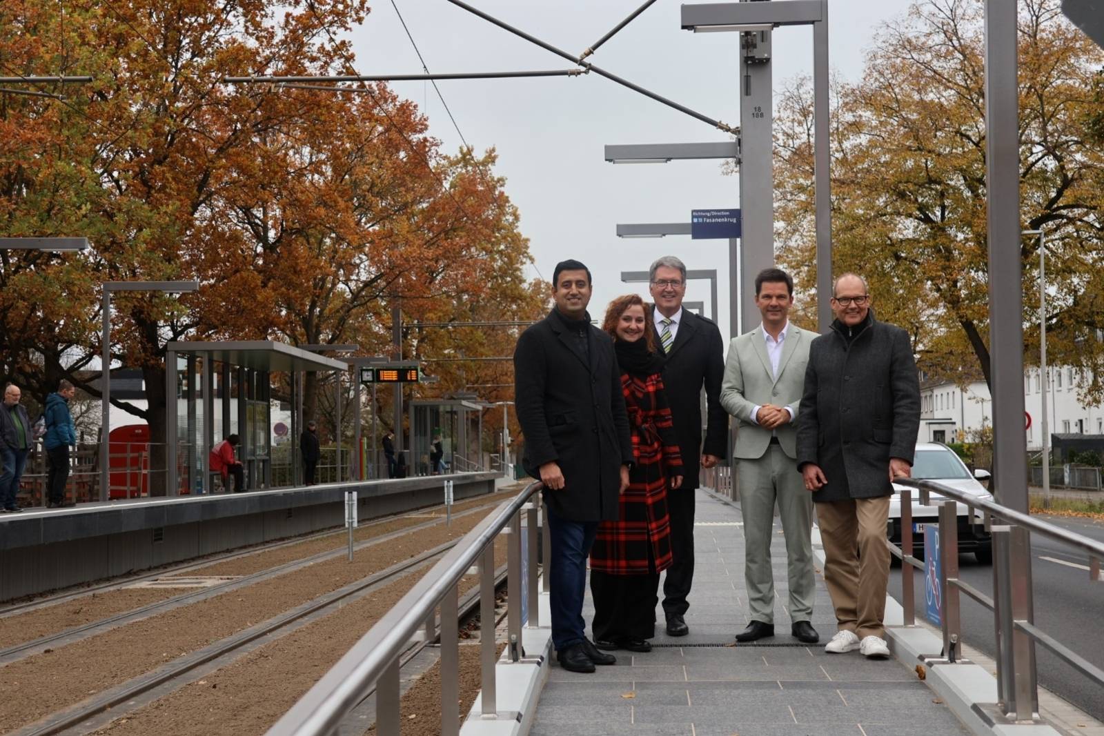 Fünf Personen auf einem neuen Hochbahnsteig der Stadtbahn