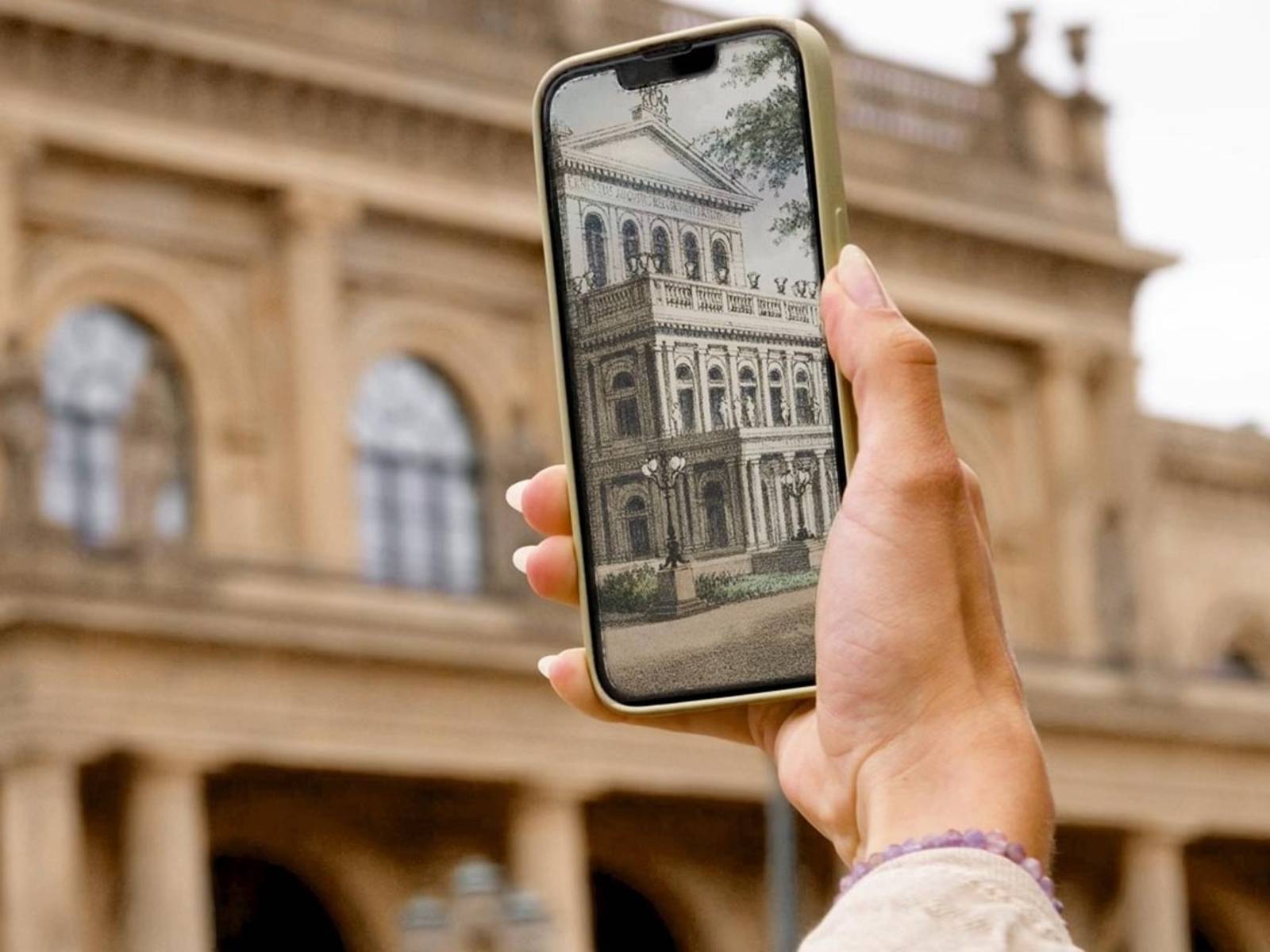 Szene aus einem Film. Eine Hand mit einem Smartphone scannt ein Gebäude.