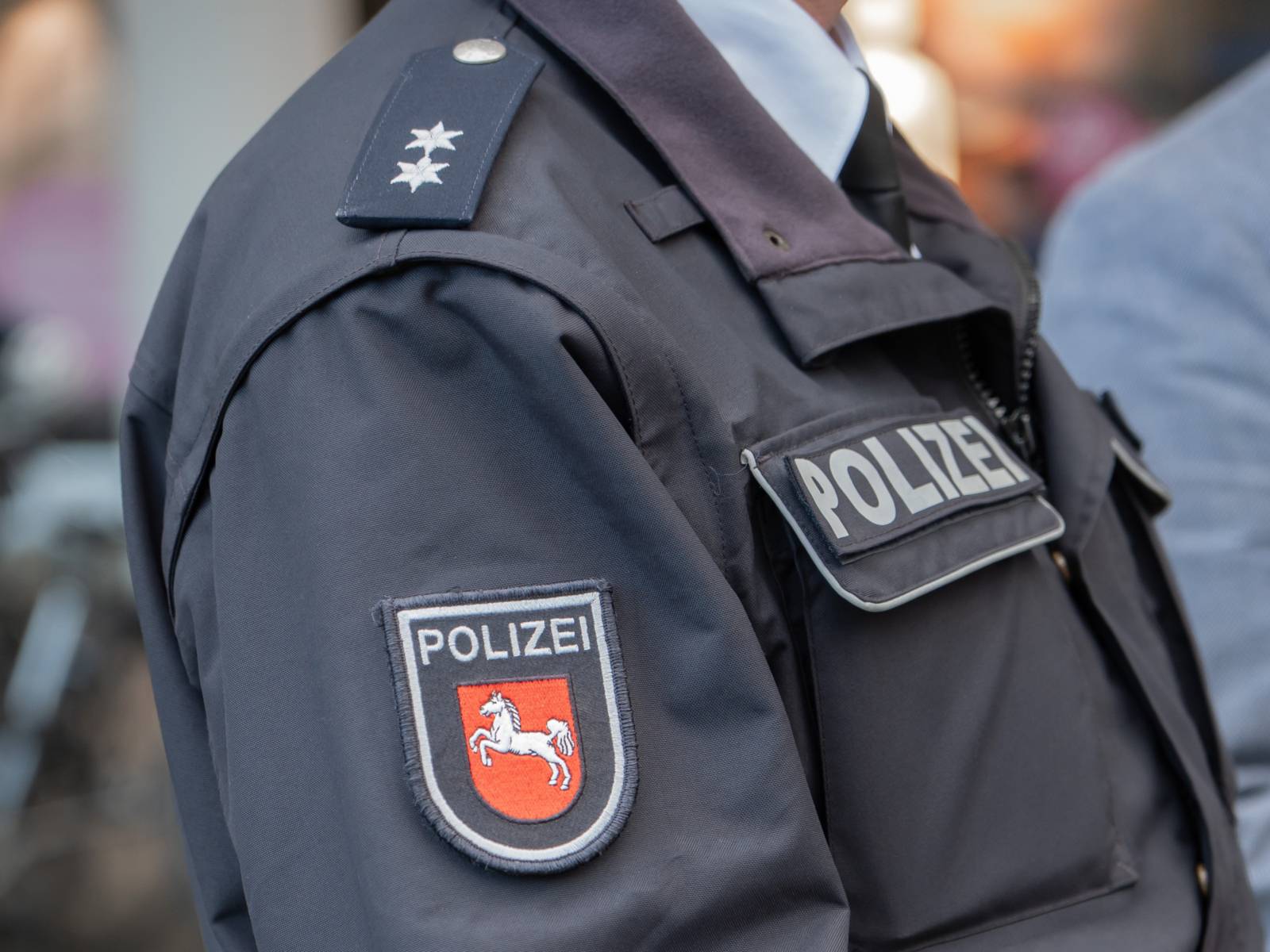 Das Bild zeigt das Wappen der Polizei Niedersachsen und eine Schulterklappe mit zwei Sternen.